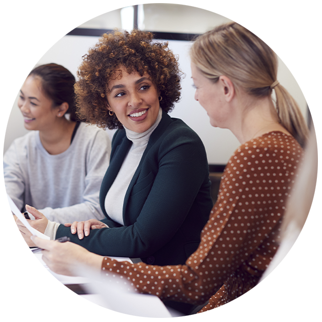 Woman smiling at another woman in office setting